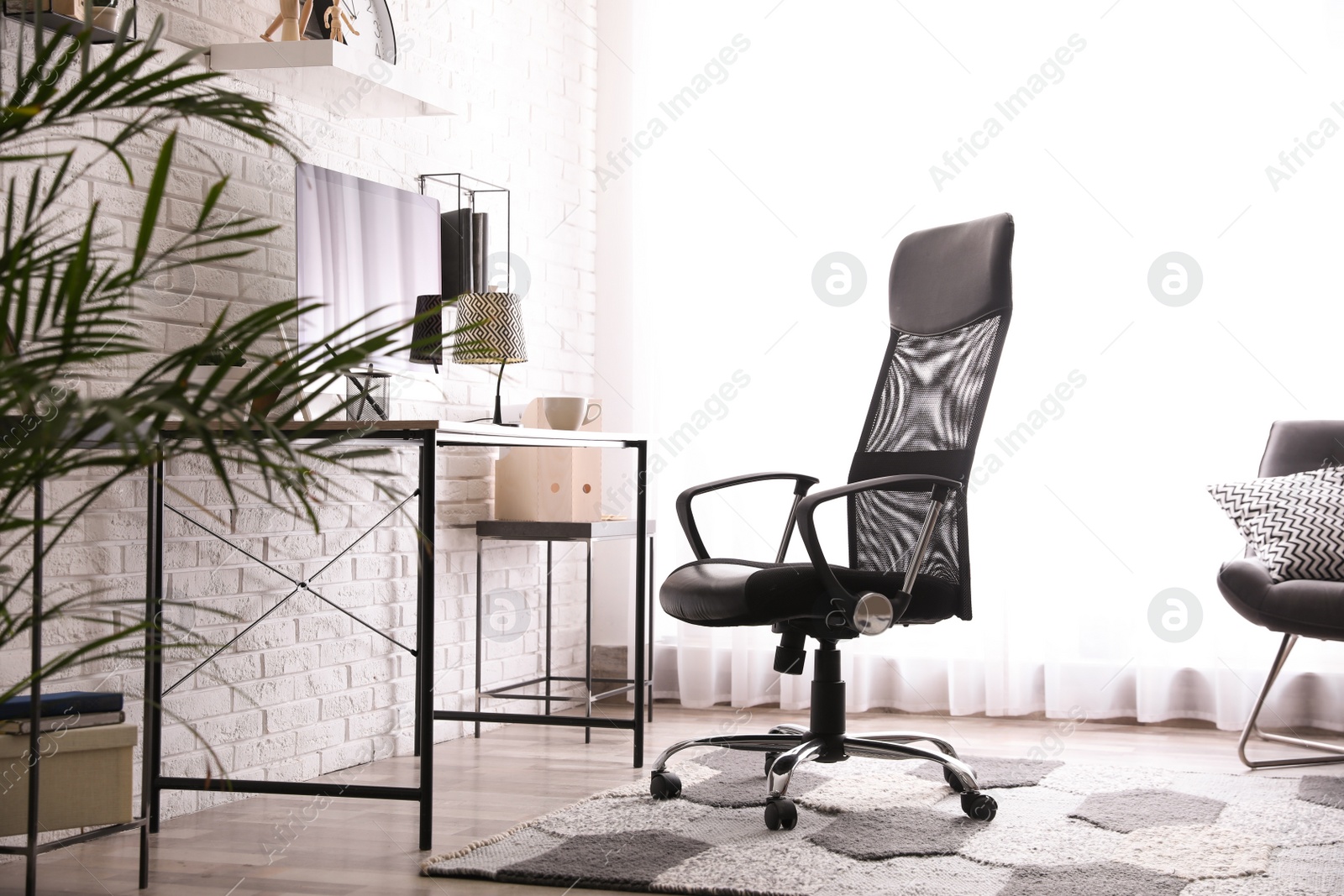 Comfortable chair near desk in modern office interior Photo of Comfortable chair near desk in modern office interior