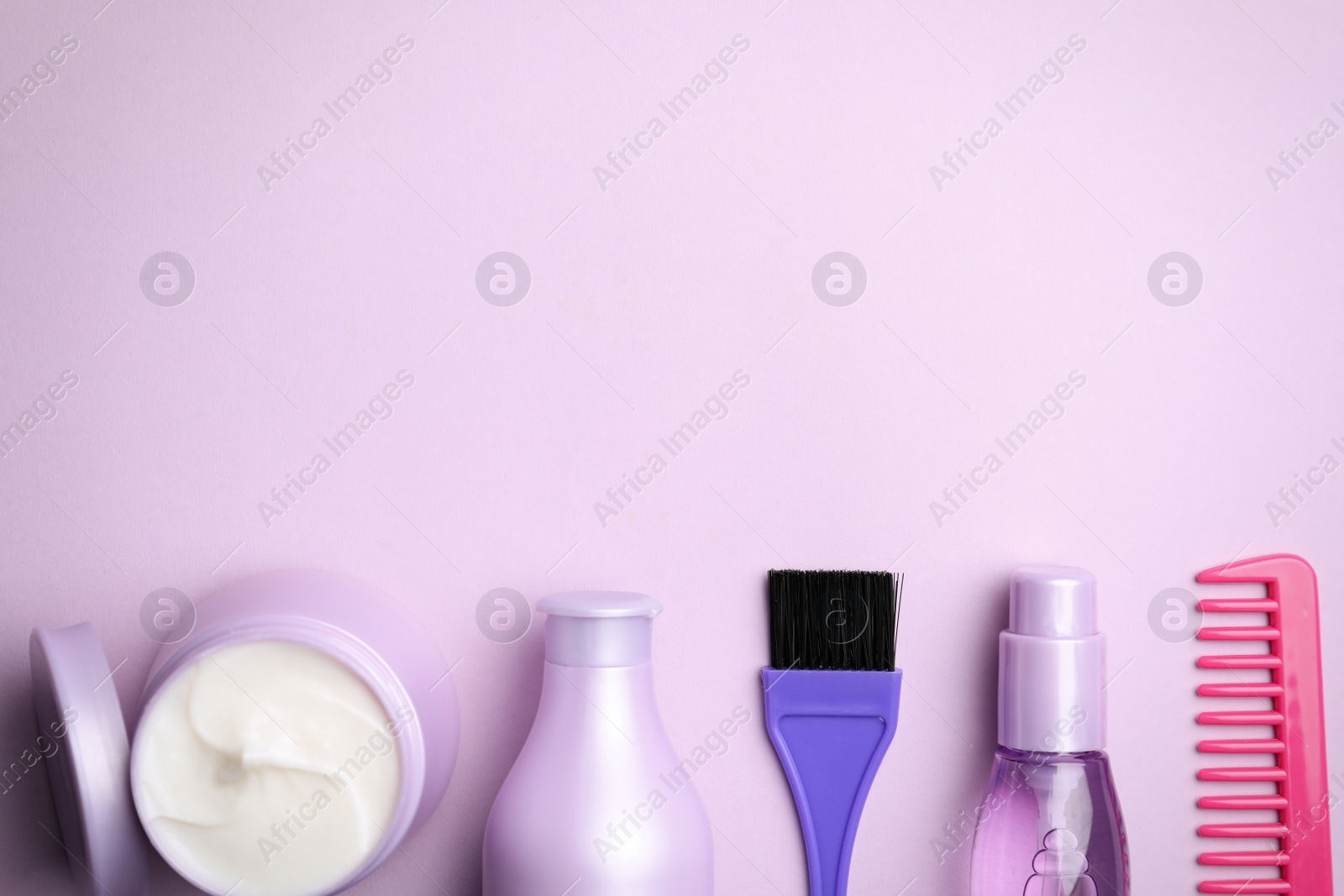 Flat lay composition with hair cosmetic products on violet background. Space for text Photo of Flat lay composition with hair cosmetic products on violet background. Space for text