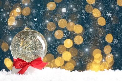 Beautiful Christmas snow globe with red bow on against blurred lights. Space for text Image of Beautiful Christmas snow globe with red bow on against blurred lights. Space for text