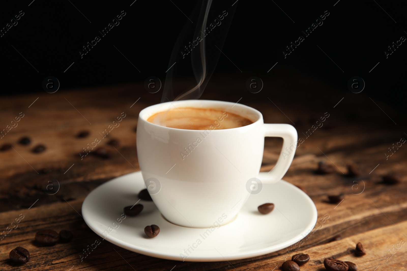 Cup of tasty coffee and beans on wooden table Photo of Cup of tasty coffee and beans on wooden table