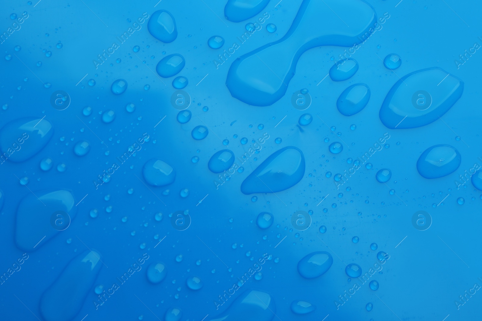 Drops of spilled water on blue background, top view Photo of Drops of spilled water on blue background, top view