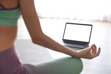 Woman having online video class via laptop at home, closeup. Distance yoga course during coronavirus pandemic Photo of Woman having online video class via laptop at home, closeup. Distance yoga course during coronavirus pandemic