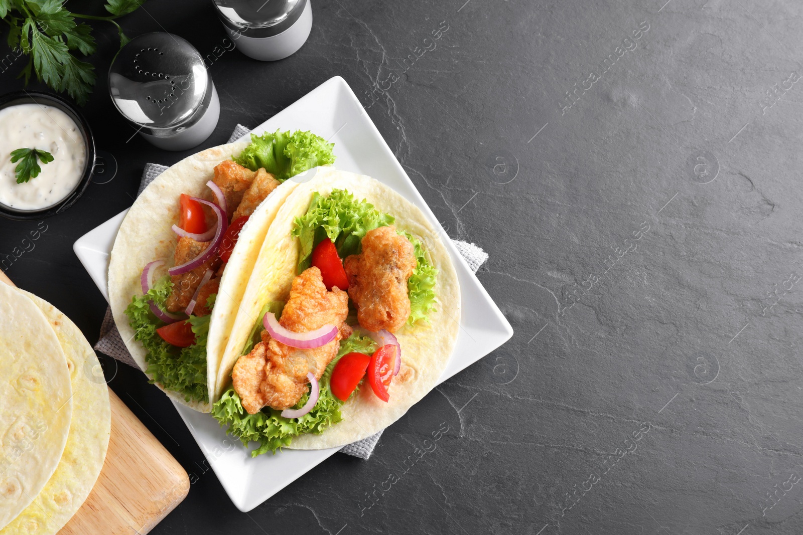Delicious fish tacos served on dark grey table, flat lay with space for text Photo of Delicious fish tacos served on dark grey table, flat lay with space for text