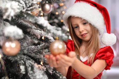 Cute little child near Christmas tree at home Photo of Cute little child near Christmas tree at home