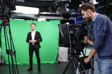Presenter and video camera operator working in studio. News broadcasting Photo of Presenter and video camera operator working in studio. News broadcasting