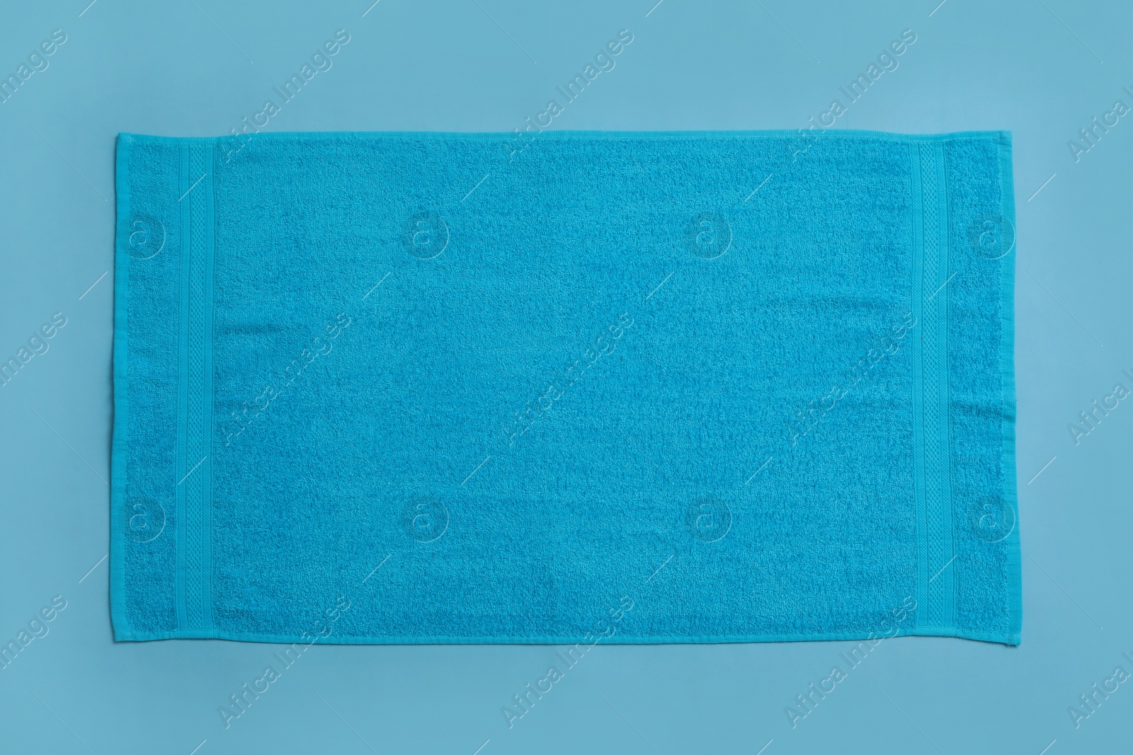 Soft beach towel on light blue background, top view Photo of Soft beach towel on light blue background, top view