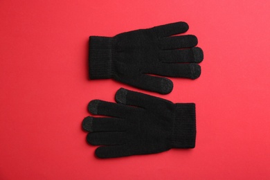 Pair of stylish woolen gloves on red background, flat lay Photo of Pair of stylish woolen gloves on red background, flat lay