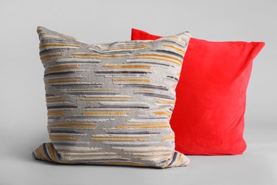 Different stylish soft pillows on grey background Photo of Different stylish soft pillows on grey background