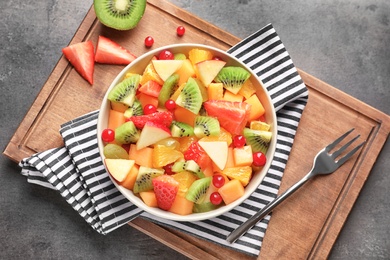 Bowl with fresh cut fruits on table, top view Photo of Bowl with fresh cut fruits on table, top view