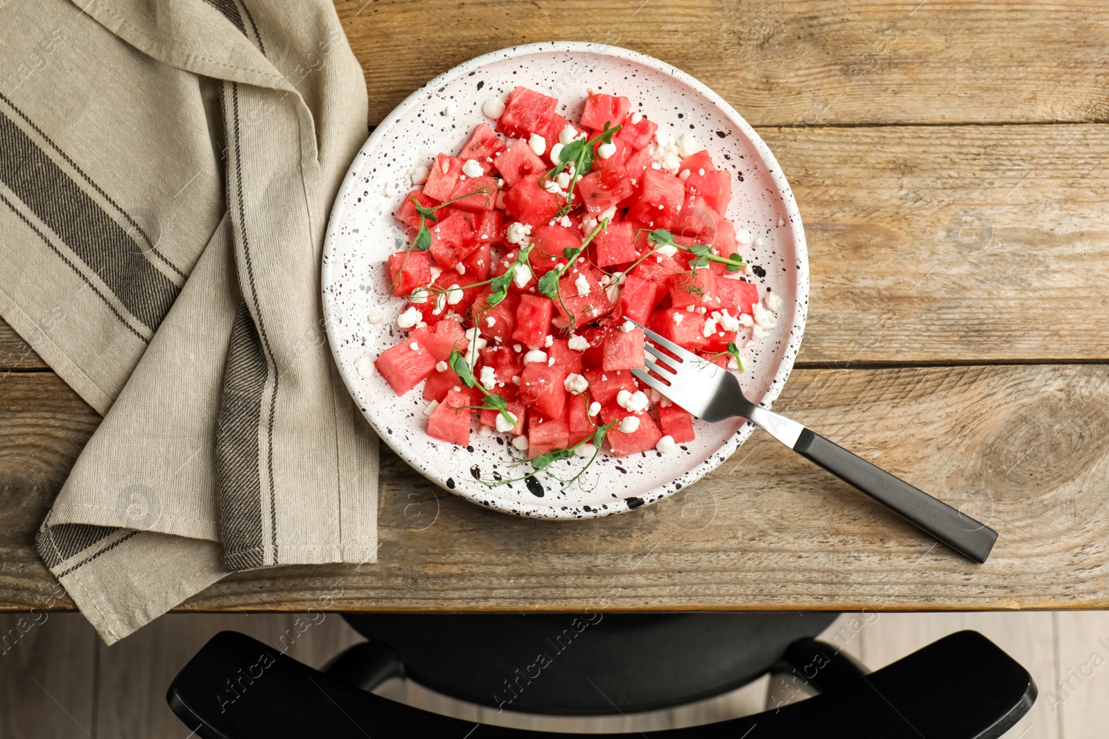 Delicious salad with watermelon served on wooden table indoors, flat lay Photo of Delicious salad with watermelon served on wooden table indoors, flat lay