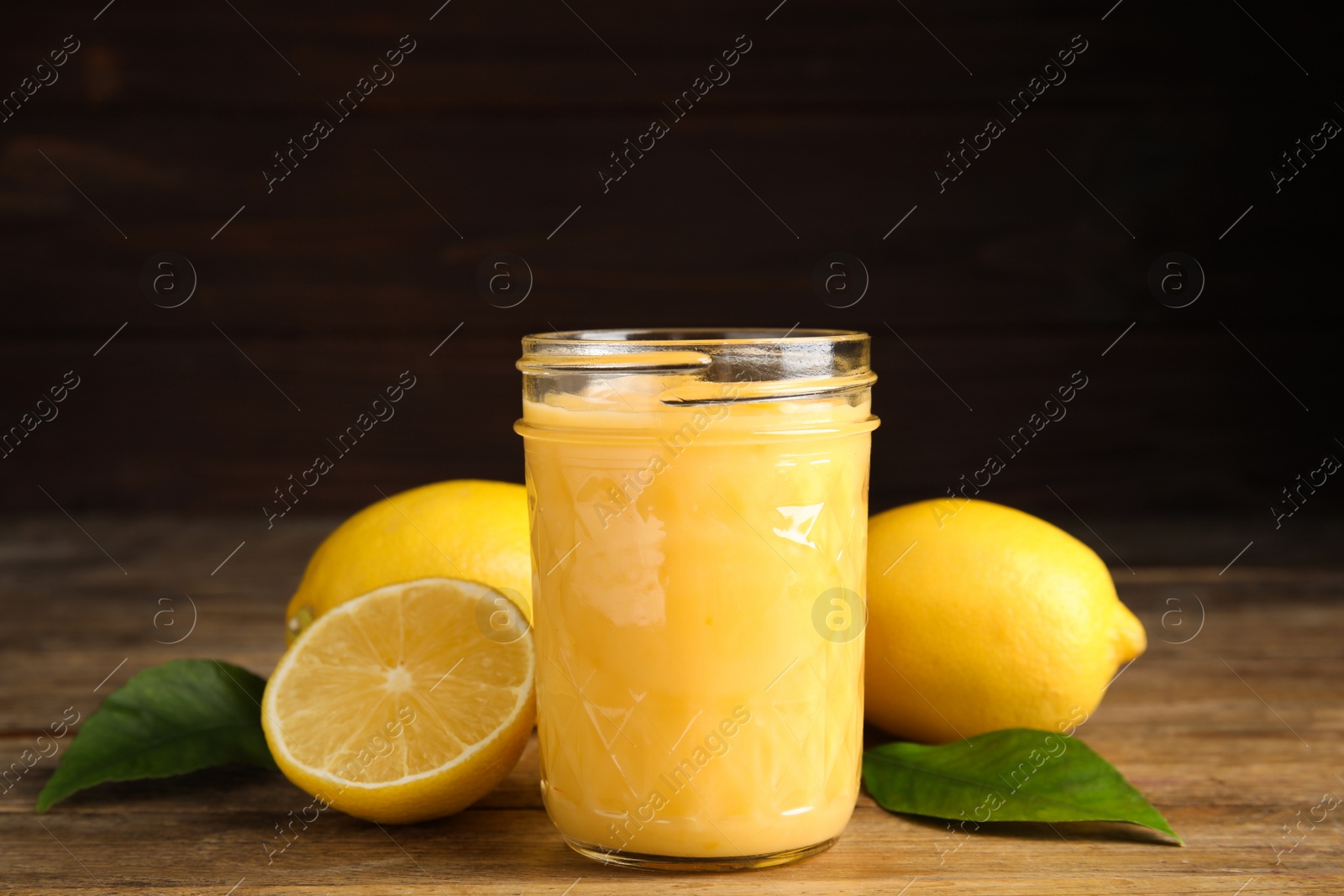Delicious lemon curd and fresh fruits on wooden table Photo of Delicious lemon curd and fresh fruits on wooden table