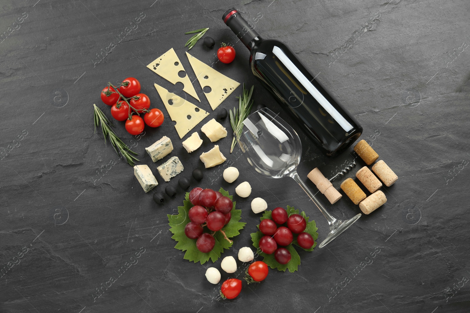 Tasty red wine and snacks on black table, flat lay Photo of Tasty red wine and snacks on black table, flat lay