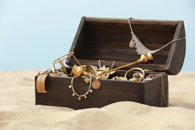 Open wooden treasure chest on sandy beach Photo of Open wooden treasure chest on sandy beach