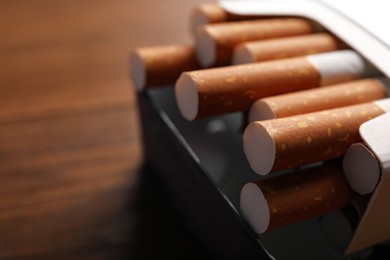 Pack of cigarettes on blurred background, closeup. Space for text Photo of Pack of cigarettes on blurred background, closeup. Space for text