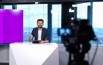 Presenter and video camera operator working in studio. News broadcasting Photo of Presenter and video camera operator working in studio. News broadcasting