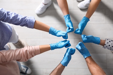 Group of people in blue medical gloves showing thumbs up indoors, top view Photo of Group of people in blue medical gloves showing thumbs up indoors, top view