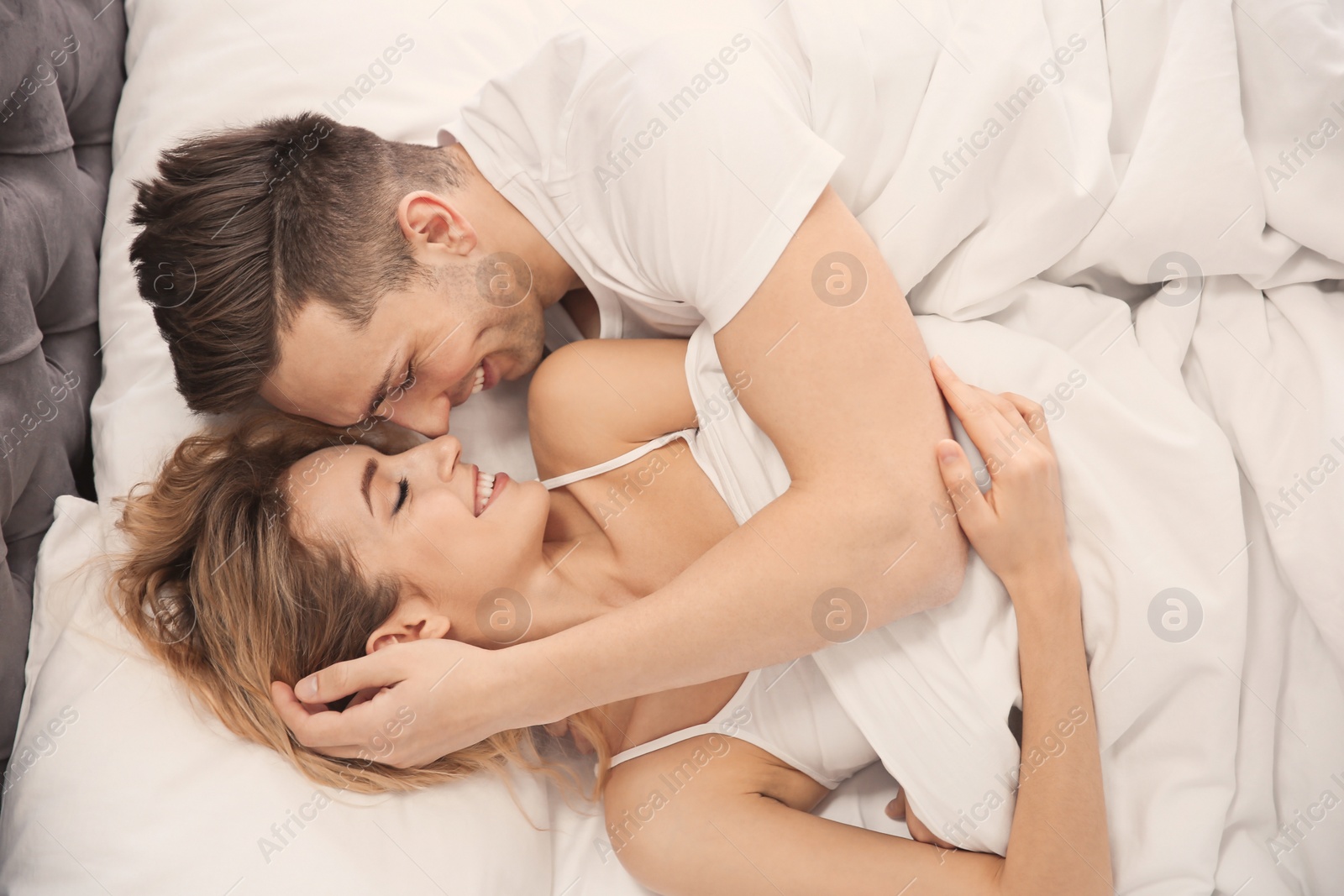 Lovely young couple hugging in bed at home Photo of Lovely young couple hugging in bed at home