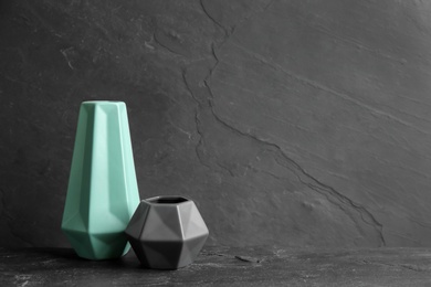 Stylish empty ceramic vases on black table, space for text Photo of Stylish empty ceramic vases on black table, space for text