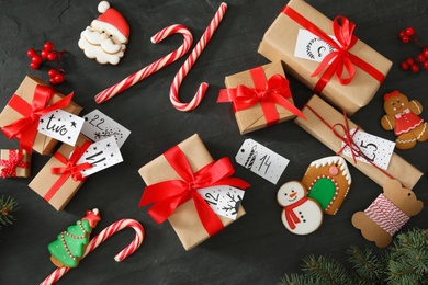 Flat lay composition with gift boxes and Christmas treats on black table. Creating advent calendar Photo of Flat lay composition with gift boxes and Christmas treats on black table. Creating advent calendar