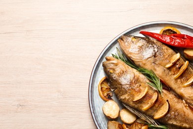Tasty homemade roasted perches with garnish on wooden table, top view and space for text. River fish Photo of Tasty homemade roasted perches with garnish on wooden table, top view and space for text. River fish