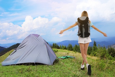 Tourist with travel backpack near camp tent in mountains. Summer vacation trip Image of Tourist with travel backpack near camp tent in mountains. Summer vacation trip