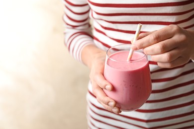 Woman with glass of tasty smoothie on beige background, closeup Image of Woman with glass of tasty smoothie on beige background, closeup