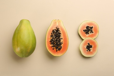 Fresh ripe papaya fruits on beige background, flat lay Photo of Fresh ripe papaya fruits on beige background, flat lay