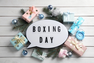 Flat lay composition with Boxing Day sign and Christmas gifts on white wooden table Photo of Flat lay composition with Boxing Day sign and Christmas gifts on white wooden table