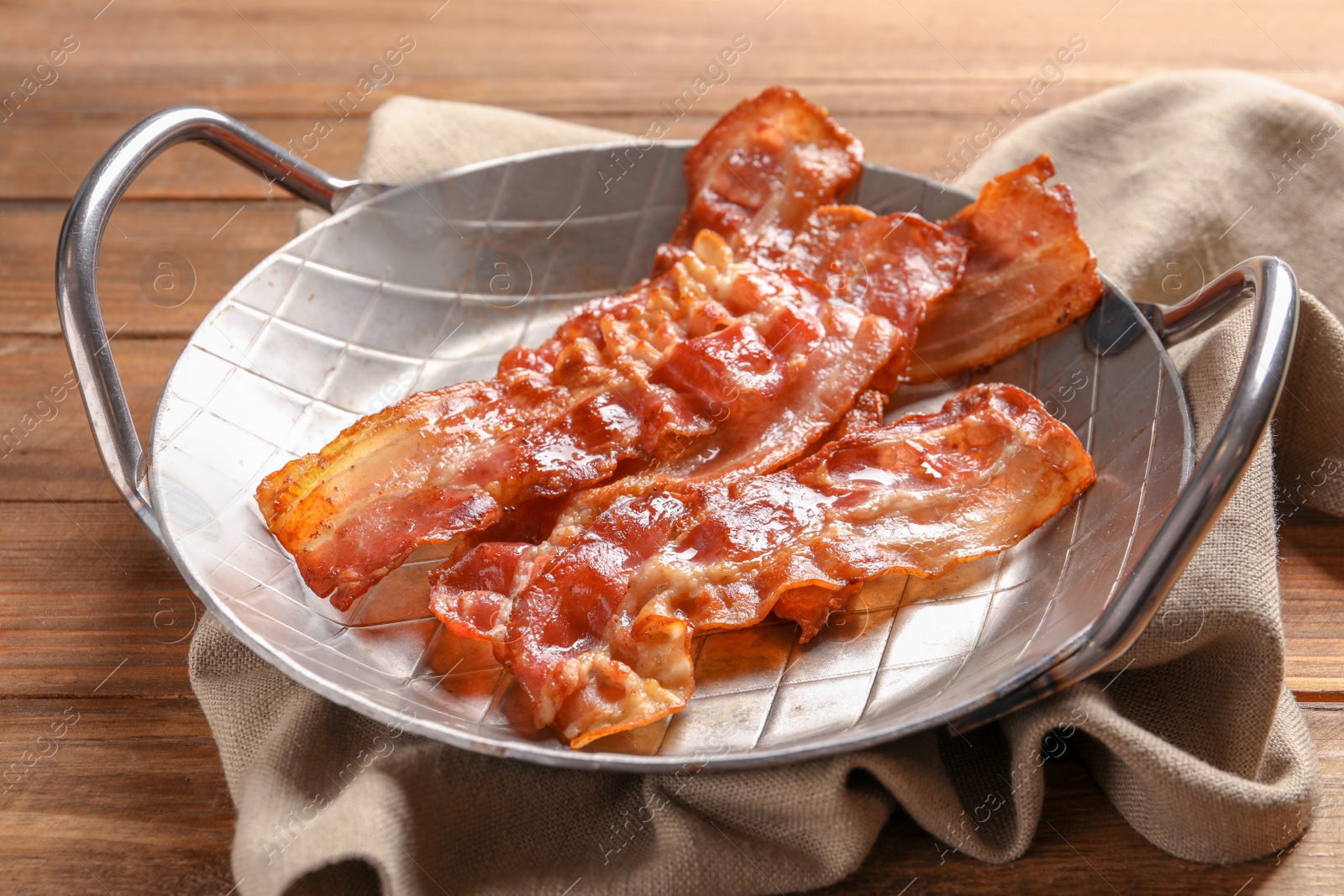 Dish with fried bacon on wooden background Photo of Dish with fried bacon on wooden background