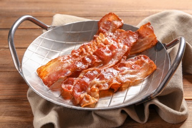 Dish with fried bacon on wooden background Photo of Dish with fried bacon on wooden background