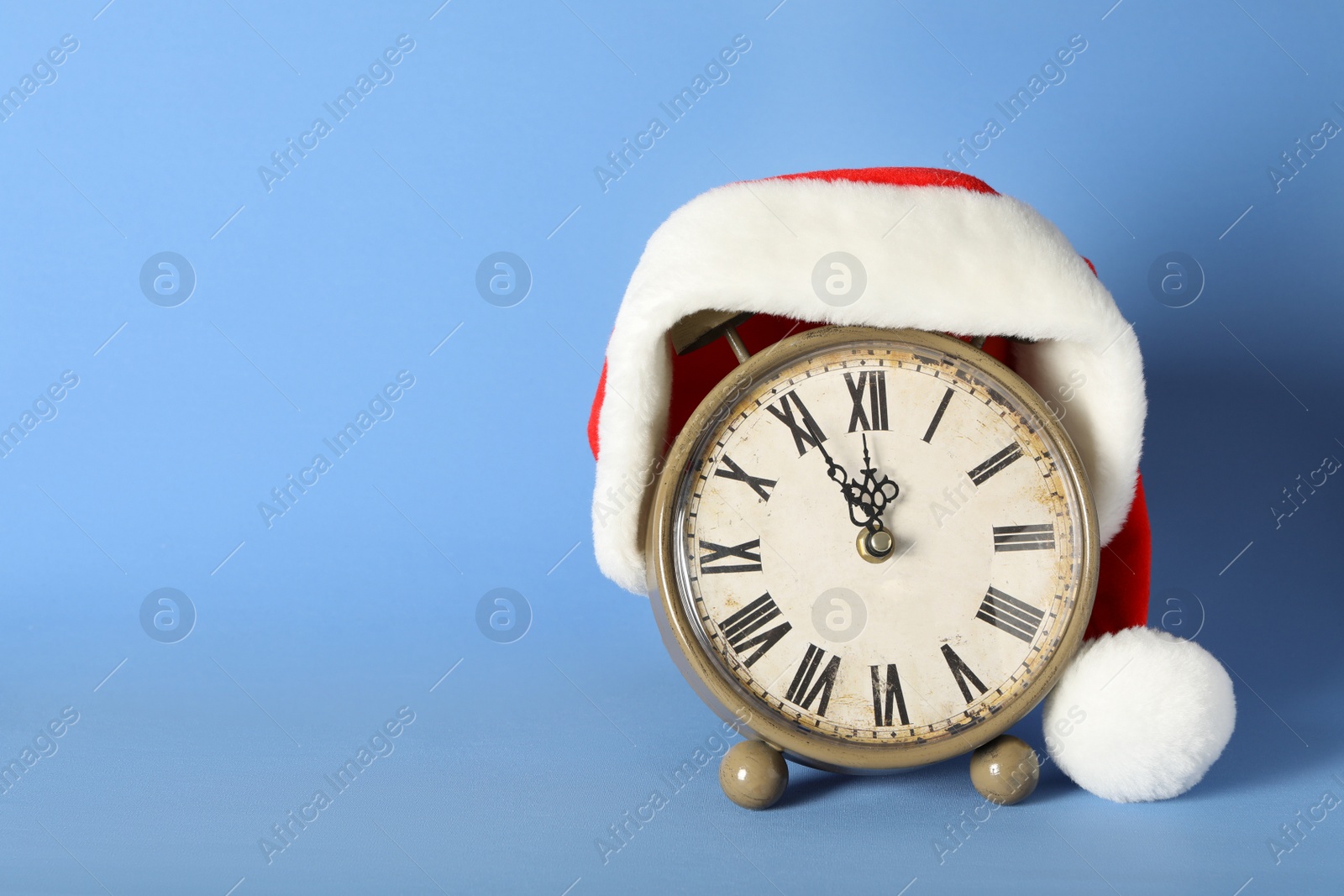 Vintage alarm clock with Christmas decor on light blue background, space for text. New Year countdown Photo of Vintage alarm clock with Christmas decor on light blue background, space for text. New Year countdown