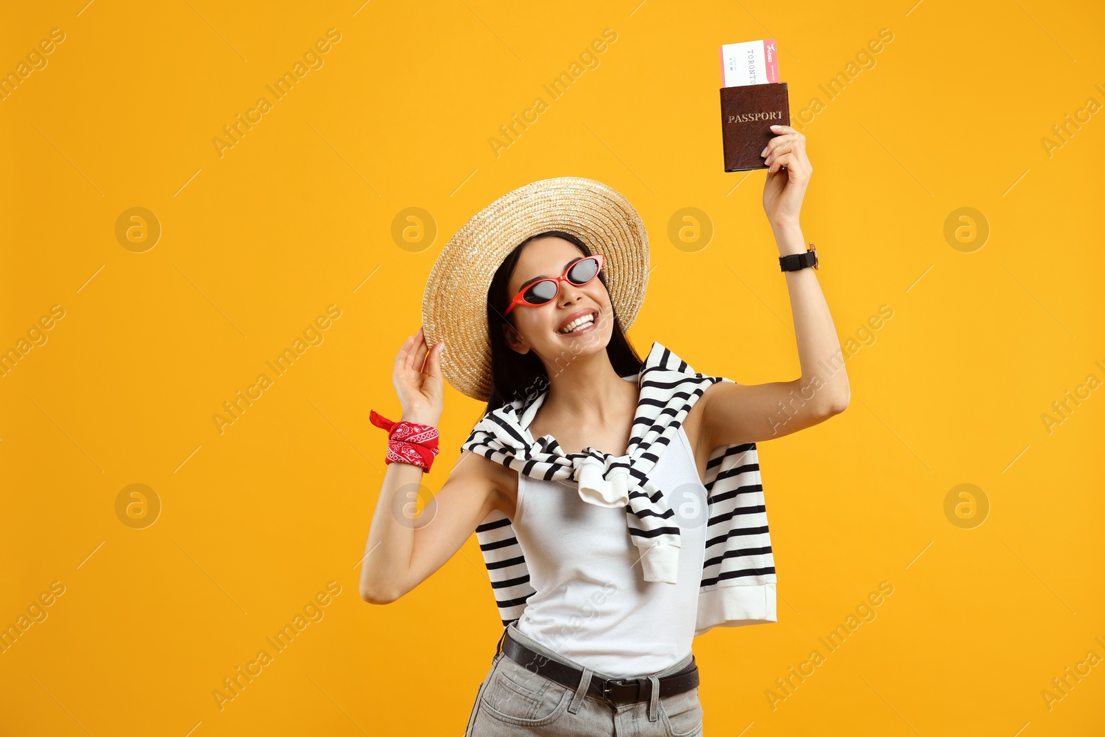Happy female tourist with ticket and passport on yellow background Photo of Happy female tourist with ticket and passport on yellow background