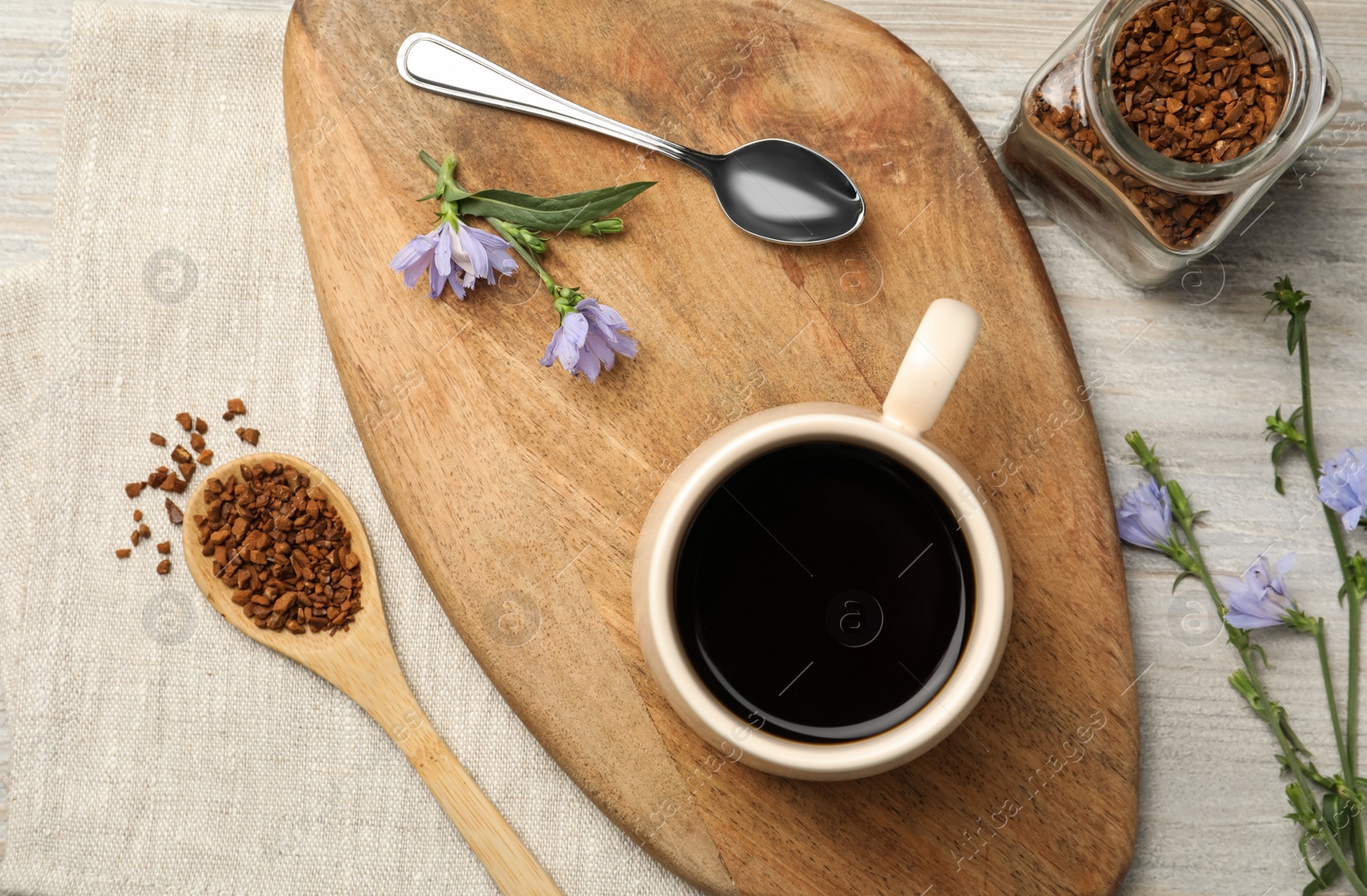 Flat lay composition with delicious chicory drink, granules and flowers on table Photo of Flat lay composition with delicious chicory drink, granules and flowers on table