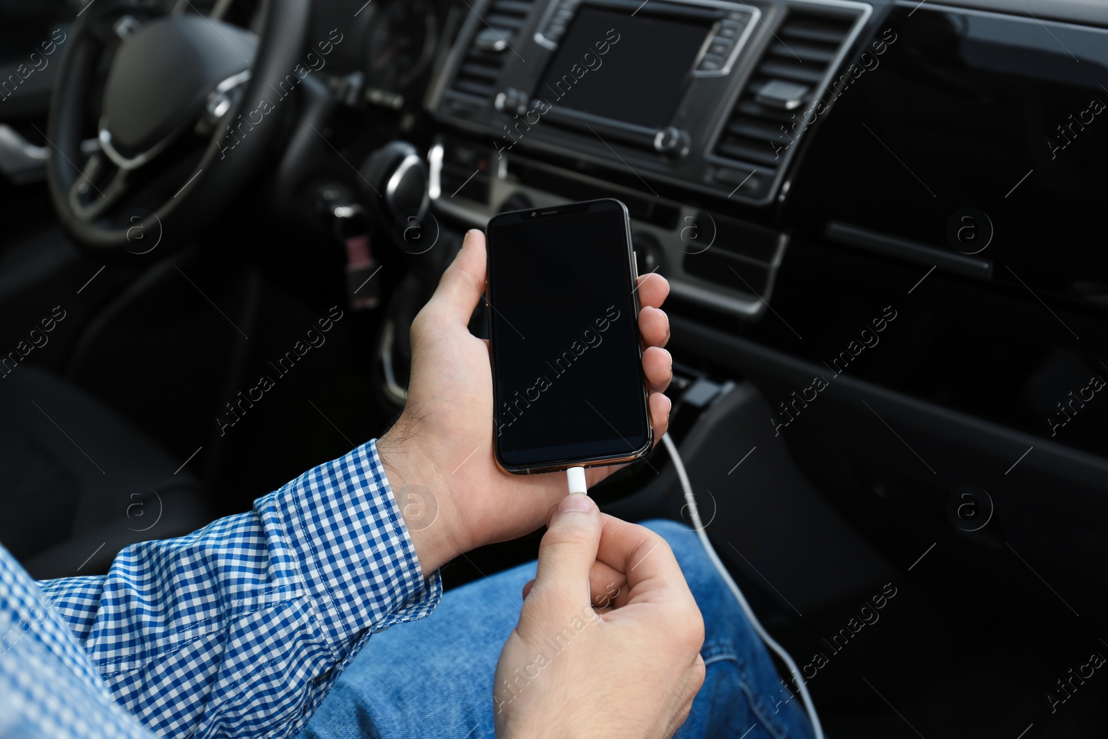 Man charging phone with USB cable in car Photo of Man charging phone with USB cable in car