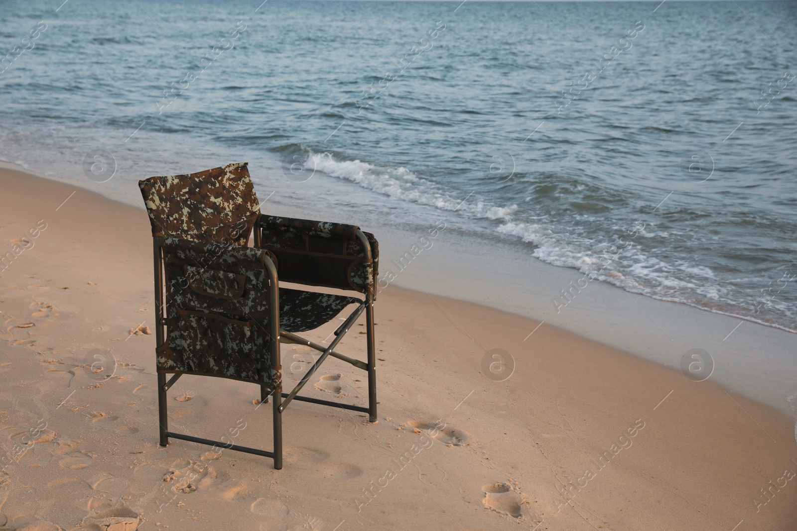 Camping chair on sandy beach near sea, space for text Photo of Camping chair on sandy beach near sea, space for text