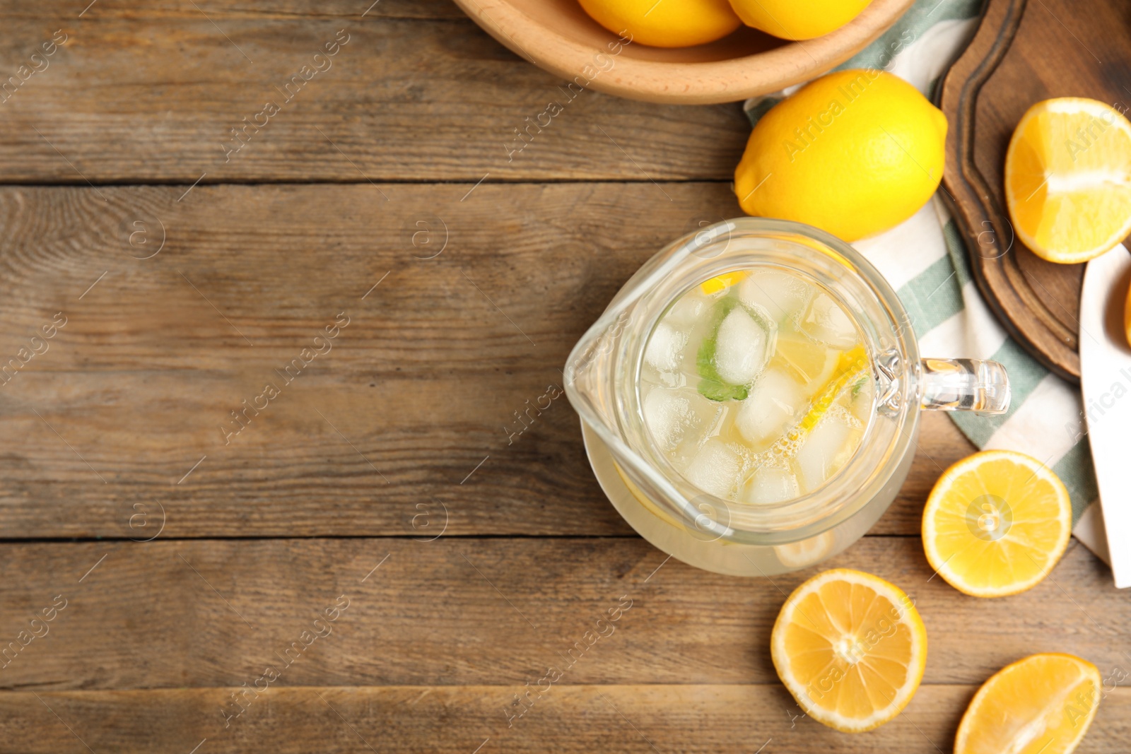 Photo of Cool freshly made lemonade and fruits on wooden table, flat lay. Space for text
