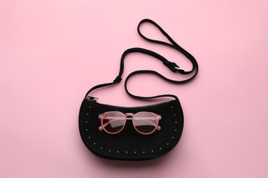 Stylish woman's bag and sunglasses on pink background, top view Photo of Stylish woman's bag and sunglasses on pink background, top view