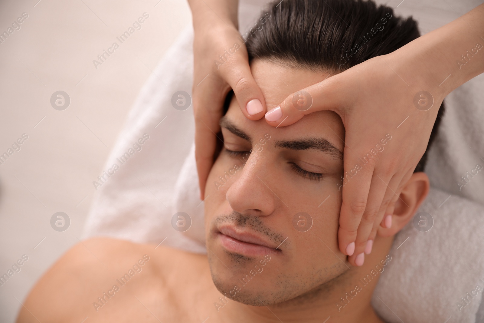 Man receiving facial massage in beauty salon, closeup Photo of Man receiving facial massage in beauty salon, closeup