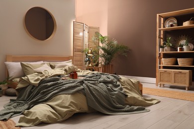 Stylish interior with large comfortable bed and potted plants Photo of Stylish interior with large comfortable bed and potted plants