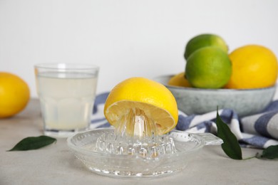 Glass squeezer with lemon and juice on light table Photo of Glass squeezer with lemon and juice on light table