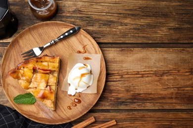 Slice of traditional apple pie with ice cream and mint on wooden table, flat lay. Space for text Photo of Slice of traditional apple pie with ice cream and mint on wooden table, flat lay. Space for text