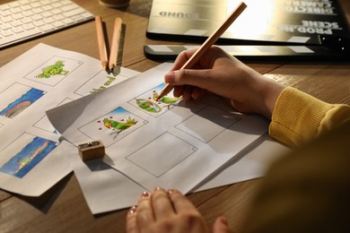 Woman drawing cartoon sketches at workplace, closeup. Pre-production process Photo of Woman drawing cartoon sketches at workplace, closeup. Pre-production process