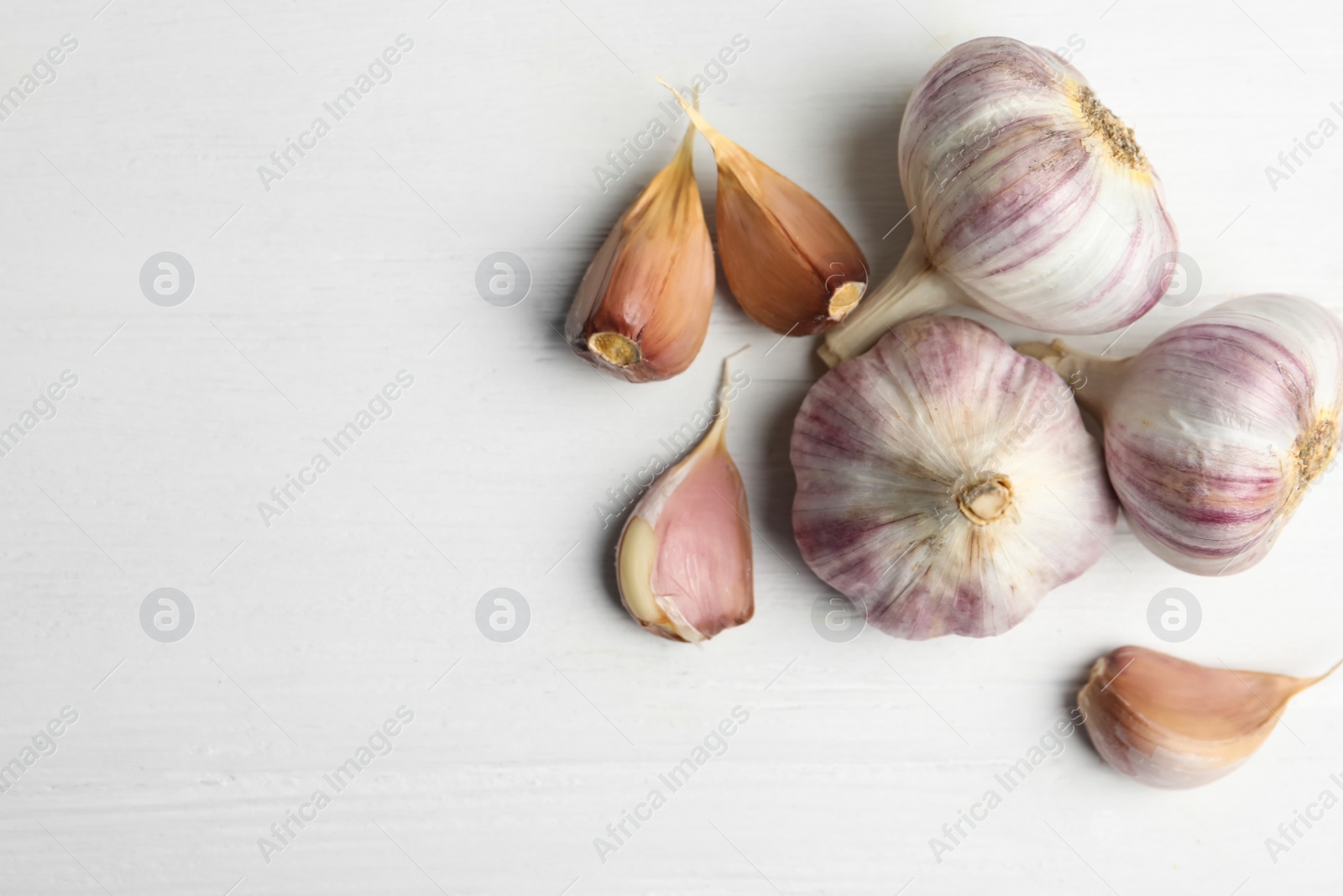 Fresh organic garlic on white wooden table, flat lay. Space for text Photo of Fresh organic garlic on white wooden table, flat lay. Space for text