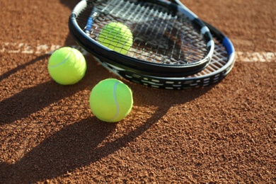 Tennis balls and rackets on clay court Photo of Tennis balls and rackets on clay court