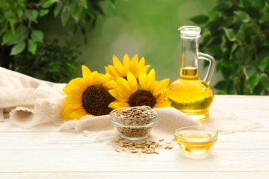 Composition with sunflower oil on white wooden table against blurred background Photo of Composition with sunflower oil on white wooden table against blurred background