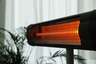 Modern electric infrared heater in room, closeup Photo of Modern electric infrared heater in room, closeup