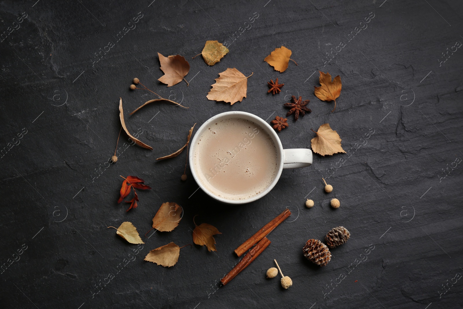 Flat lay composition with cup of hot drink and autumn leaves on black table. Cozy atmosphere Photo of Flat lay composition with cup of hot drink and autumn leaves on black table. Cozy atmosphere