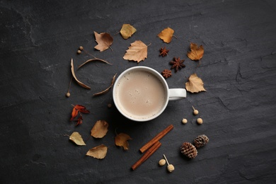 Flat lay composition with cup of hot drink and autumn leaves on black table. Cozy atmosphere Photo of Flat lay composition with cup of hot drink and autumn leaves on black table. Cozy atmosphere