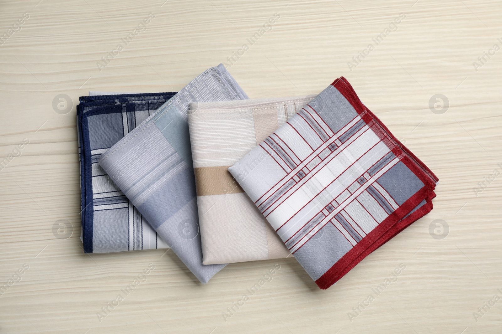Stylish handkerchiefs on white wooden table, flat lay Photo of Stylish handkerchiefs on white wooden table, flat lay