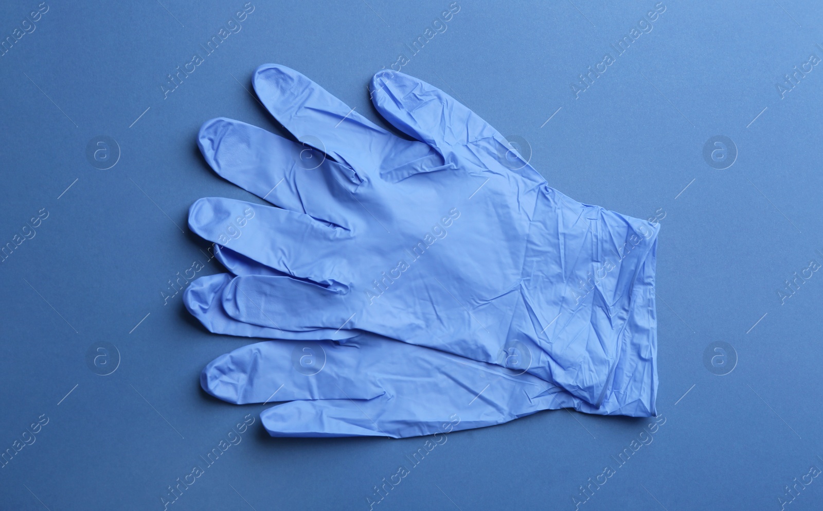 Pair of medical gloves on blue background, flat lay Photo of Pair of medical gloves on blue background, flat lay